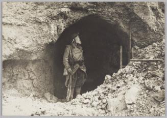 [soldier wearing a gas mask in a dugout]