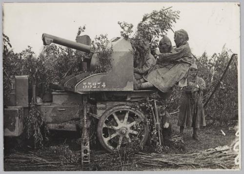 [soldiers in gas masks sitting at a gun]