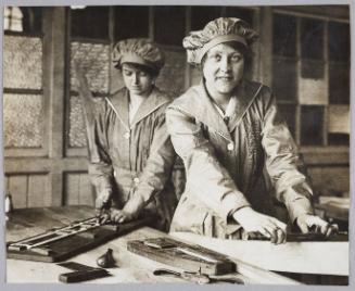 Aeroplane framing and building is now being taught by the L.C.C. at Ferndale-road School, Brixton. Women are being trained as aeroplane assemblers and it is found that the work is quite within their capabilities. The training is free and lasts three or four weeks. Twenty-five shillings a week is paid during the course to each pupil willing to accept a post away from home. Others receive 18s. per week. Railway fare is paid for pupils coming from the country. Women at work on one of the struts