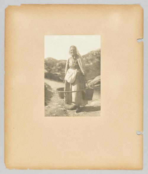 [Smiling woman holding pails and wearing a hoop] Page 37 of Newfoundland from Collection of Canadian albums compiled by Edith S. Watson
