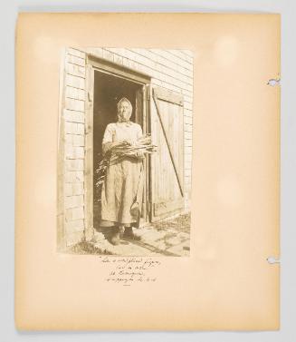 "Like a sculpt[u]red, figure, cod in arm." At Lameque, Shippegan Is, [N.B.] Page 22 of Fish; from collection of Canadian albums compiled by Edith S. Watson, 1890s-1930s