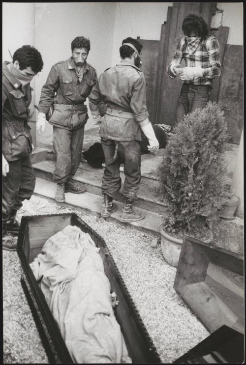 Soldiers and volunteers with covered faces work at preparing the victim's bodies for burial at the Osoppo cemetery after the 1976 Friuli earthquake