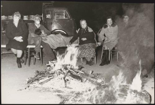 Neighbours and family sit around a fire in a refugee camp in the aftermath of an earthquake in Tuscany that left about 5,000 homeless