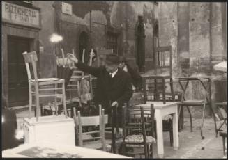 A gentleman stacks chairs in the aftermath of an earthquake in Tuscany that left about 5,000 homeless