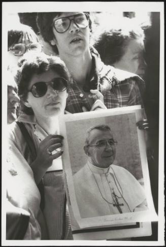 A woman holding a picture of Pope John Paul I in a crowd after his death, in September 1978