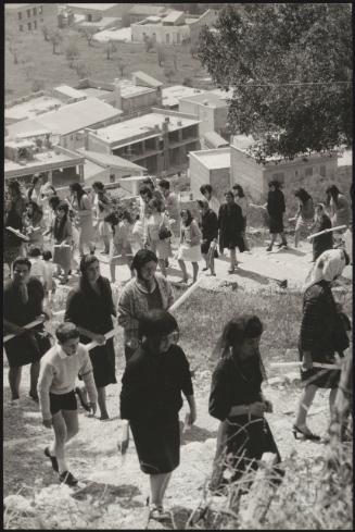 A procession of women and children holding church candles climb a village hill on the day of the 'Candelora' (Candlemas), which is the 2nd of February