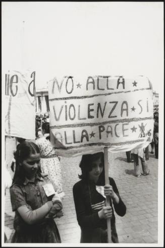 Two young girls in St. Peter's Square, one holding a banner that reads "No to Violence, Yes to Peace"