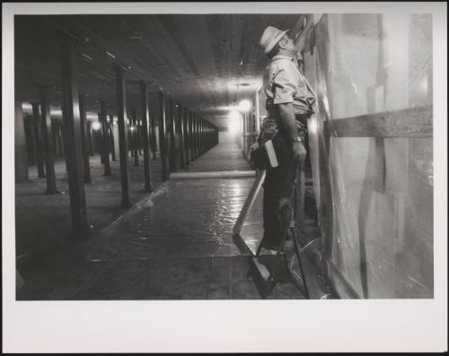 Construction workers hang plastic sheeting 