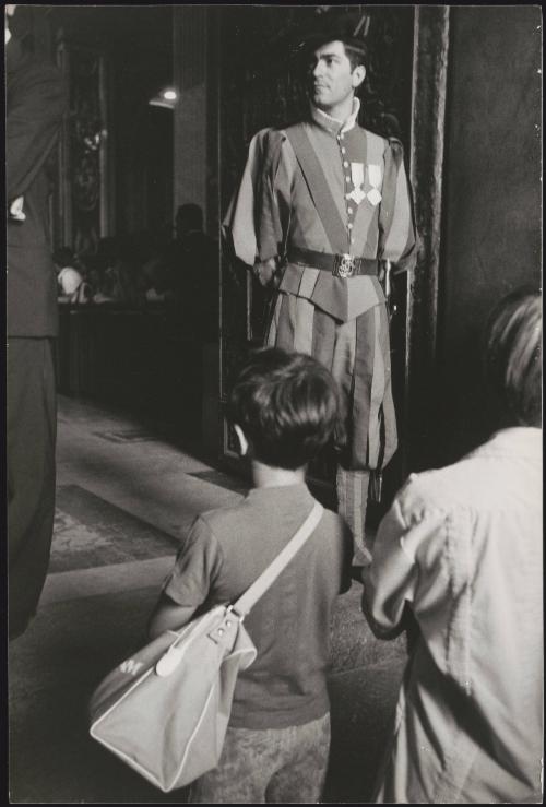 A boy and his mother arriving at the Vatican City, Swiss Guard standing at the door