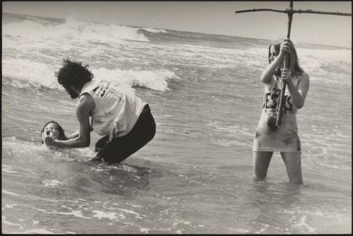 Religious hippies carry out a baptism in the sea