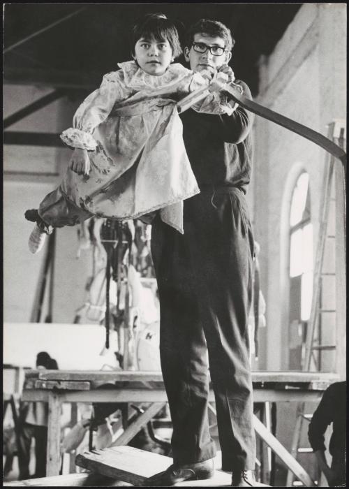 Children being prepared for a religious procession, dressed as angels and suspended on structures to appear as though they are flying