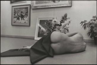 Diana Ortense poses nude on the floor surrounded by paintings