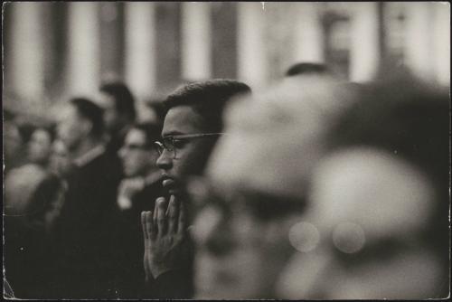 A young man praying amongst others 