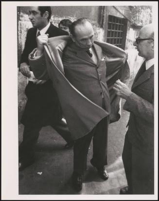Paolo Bonomi takes off his coat on the street