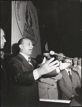 Vito Miceli speaking into a microphone at a meeting of the MSI (Italian Social Movement)