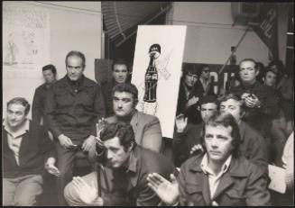 Attendees applauding, at a Coca-Cola factory workers' union meeting