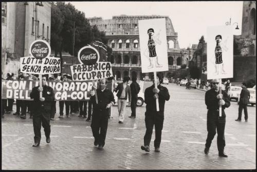 Factory workers from a Coca-Cola bottling factory, march down the street in protest
