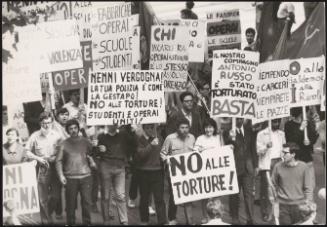 People marching down the street carrying protest placards at a student rally