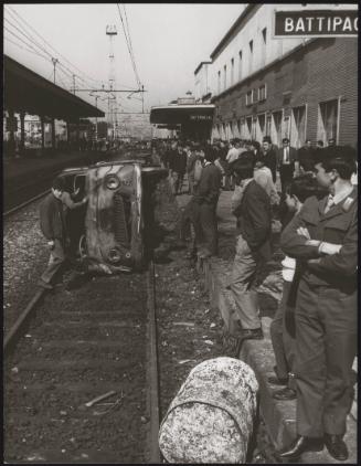 A burnt out car lies on railway tracks at a station, Battipaglia, 1969