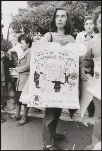 A girl holds up her hand-drawn poster made for a demonstration by the Radical Party