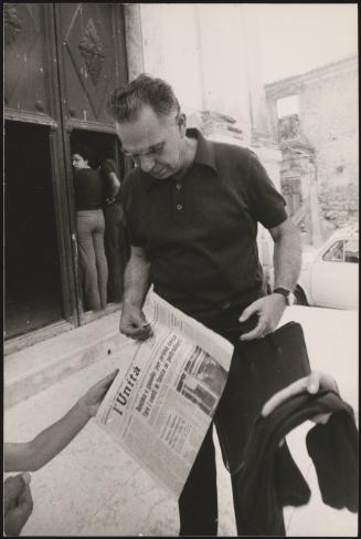 A man holding a copy of L'Unita