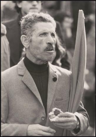 Portrait of a man holding a flag under his arm 