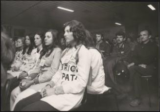 Factory workers sit in at a strike meeting