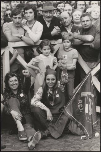 A crowd gather by a barrier at a pro communist protest