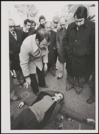 Carlo Moro with Masono, chief of the street patrol police, inspect the body of Martino Zicchitella