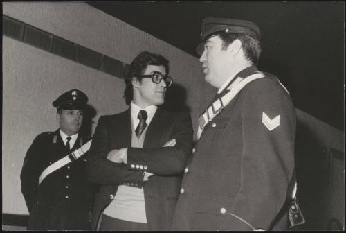 The activist Achille Lollo stands between two officials