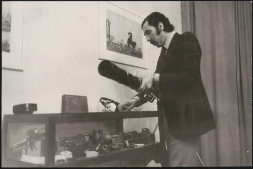 A man inspects a vitrine of camera equipment