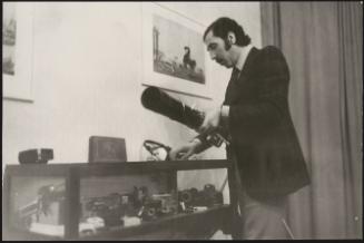 A man inspects a vitrine of camera equipment