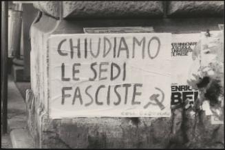 A hand written communist poster pasted on a wall on a street corner
