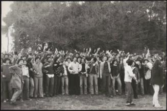 A crowd of protesters take their stand in a field