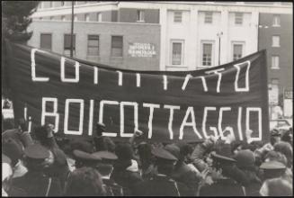 A large banner is held up at a heavily guarded unspecified demonstration 