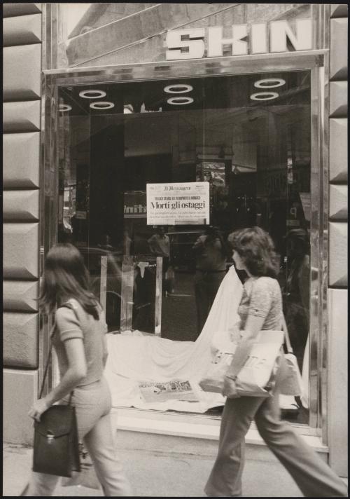 Two women walk past an empty shop on Via due Macelli in Rome