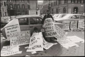 Two men with many hand written protest posters against the rising prices of petrol 