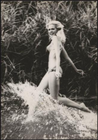 Actress Alicia Brandet running through water in a bikini