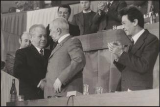 Anshei Kirilenko shakes hands with another man, looked on by Enrico Berlinguer of PCI at PCI congress, March 18th - 23rd 1975, Rome
