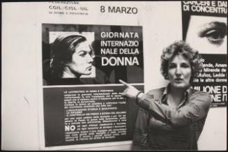 Doriana Giudici points to a poster promoting International Women's Day
