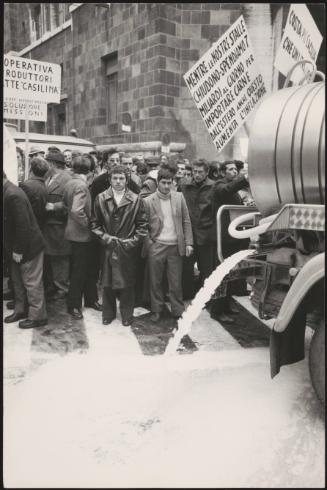 A vehicle floods the street with milk at a farmer's demonstration