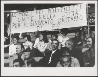 Wives of policeman hold a banner proclaiming their support for the Police union