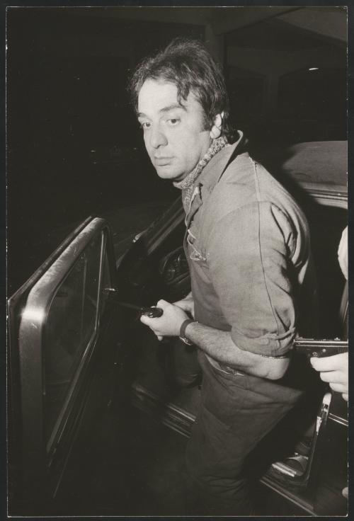 An undercover police man gets into a car holding a gun