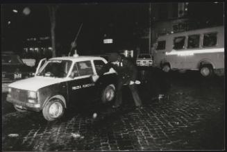 Policeman and car during night riot