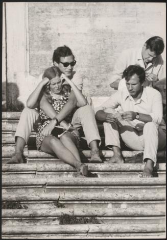 An Italian 'Pappagalli' man relaxing with his female tourist on the Spanish Steps, Rome