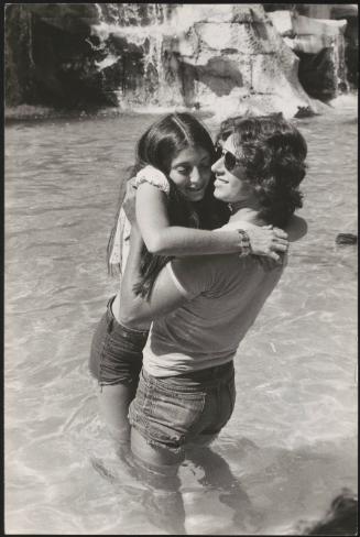An Italian 'Pappagalli' man picks up a female tourist at the Trevi fountains, Rome