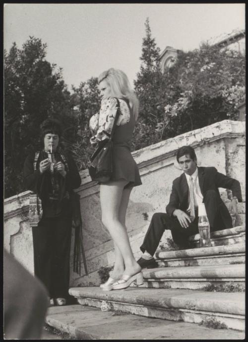 An Italian 'Pappagalli' man sits with two female tourists