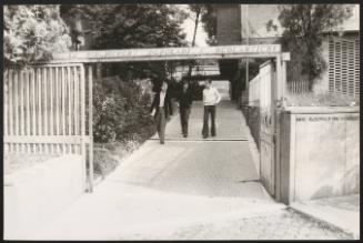 Three students walk from the library of a university