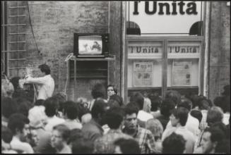 Crowd watching a political debate on TV during a rally