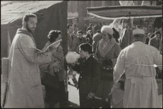A boy eating candy floss at a busy market in Piazza Navona, Rome